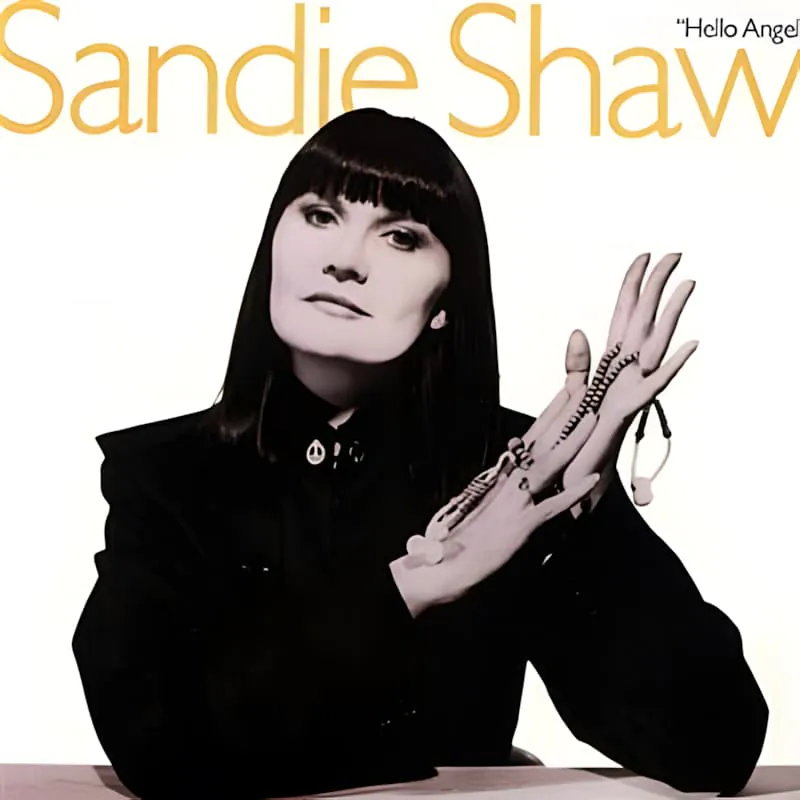 Une photo en noir et blanc de la chanteuse pop anglaise Sandie Shaw, avec son nom écrit dans une police stylisée au-dessus d'elle.