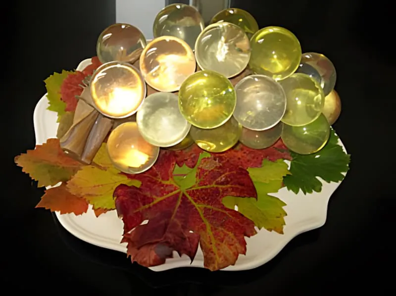 Verres de vin disposés avec des feuilles de vigne d'automne colorées sur une assiette blanche